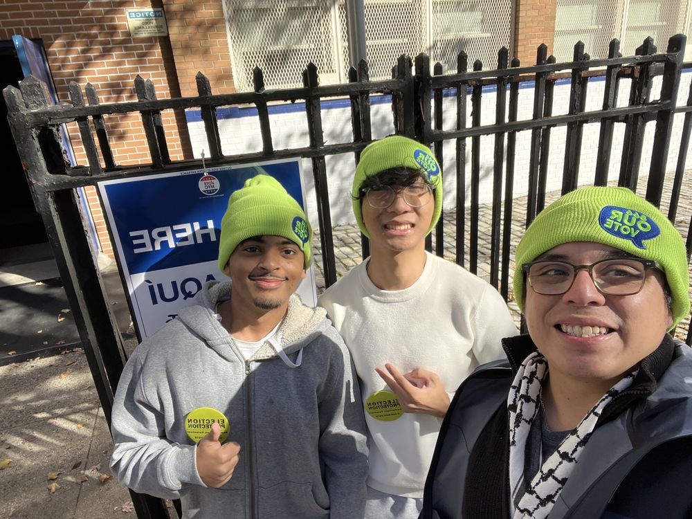 Three election protection volunteers outside a polling place